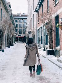 Rear view of woman walking on street in city