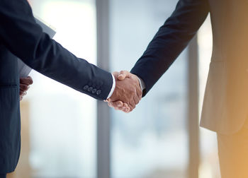 Midsection of business people shaking hands