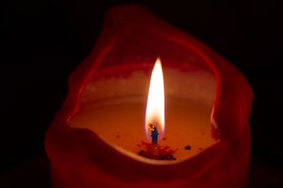 Close-up of illuminated candle against black background