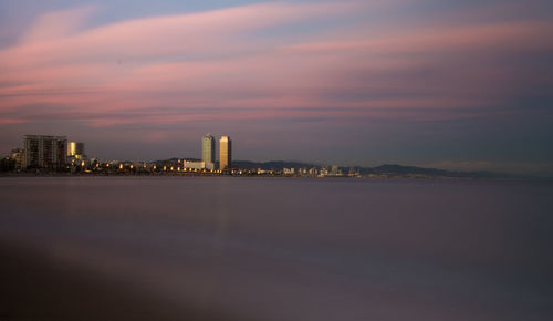 View of city lit up at sunset