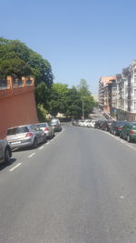 Cars on road in city against clear sky