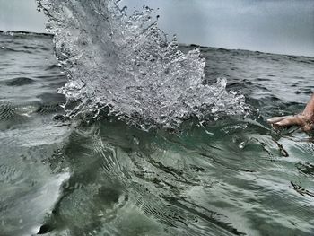 Close-up of wave splashing on sea against sky