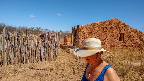 Rear view of woman standing against blue sky