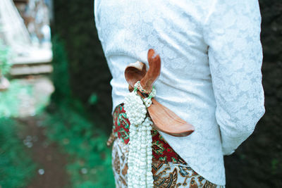 Rear view of woman holding leaf