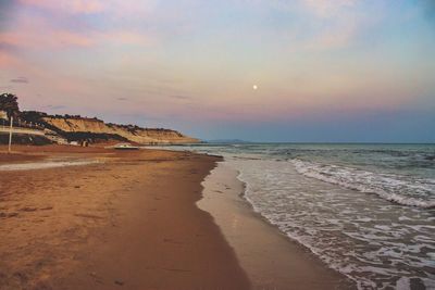 Scenic view of beach against sky during sunset