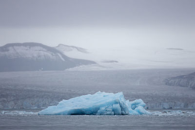 Blue ice iceberg in front of a glacier at svalbard