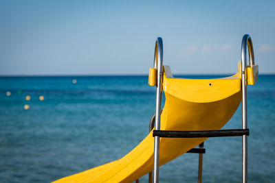 Yellow flag on sea against clear sky