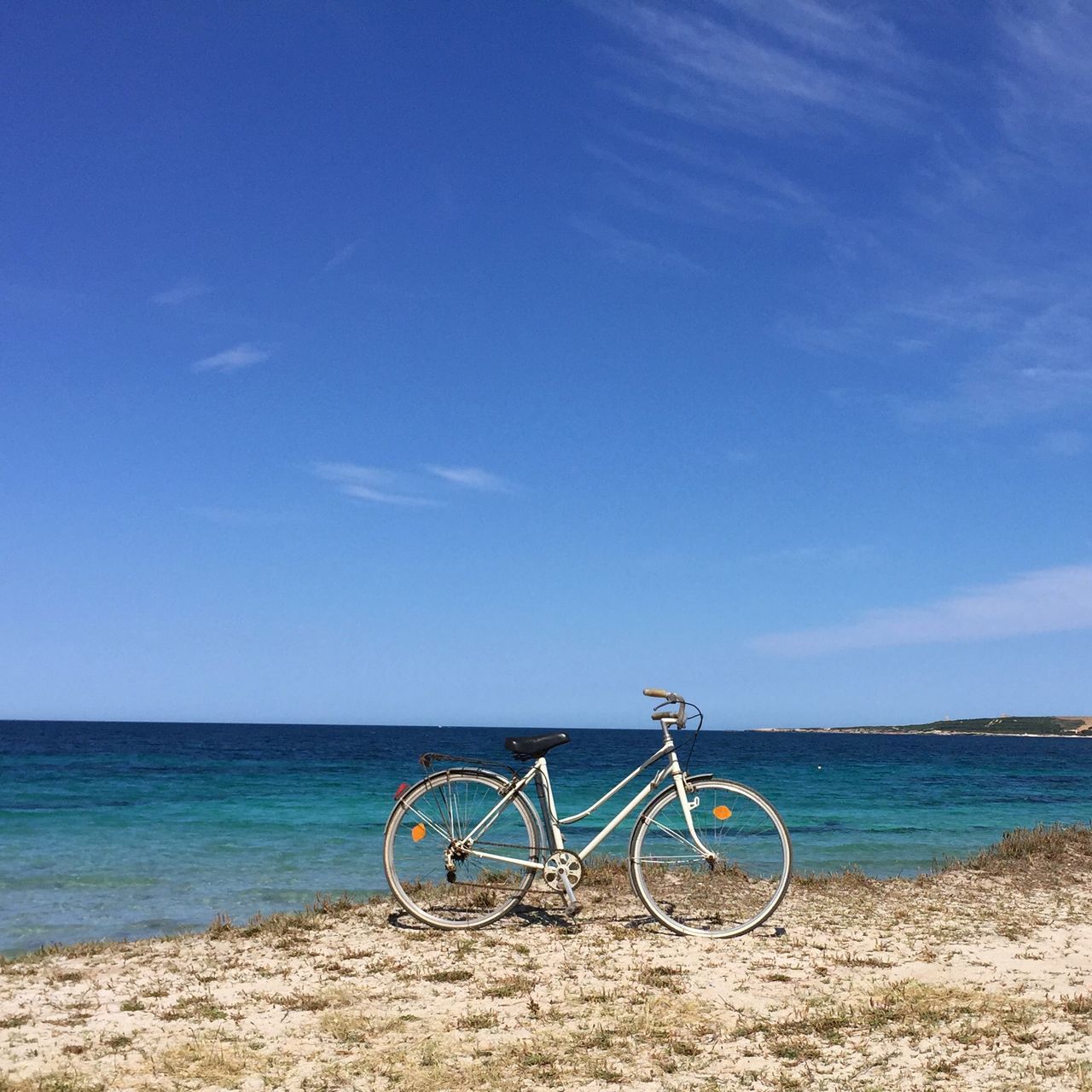 sea, water, horizon over water, bicycle, beach, blue, transportation, tranquility, shore, mode of transport, sky, tranquil scene, scenics, beauty in nature, nature, parking, sand, stationary, day, outdoors