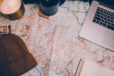 High angle view of laptop and map on table