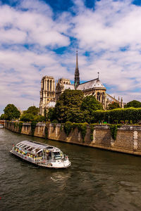 Bridge over river by building against sky
