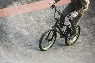 Low section of man riding bicycle on road