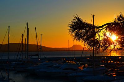 Boats moored on sea against sky during sunset