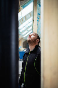 Man in protective clothing looking up while standing at construction site