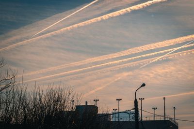 Scenic view of vapor trails in sky at sunset
