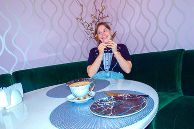 Young woman drinking glass on table
