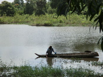 Man sitting on boat sailing in river