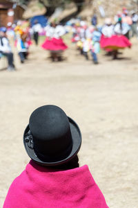 Rear view of woman wearing hat standing on street