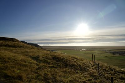 Scenic view of landscape against bright sun