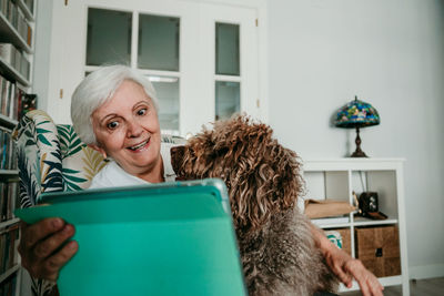 Smiling senior woman taking selfie with dog