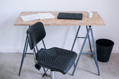 Empty chair by laptop on desk in office