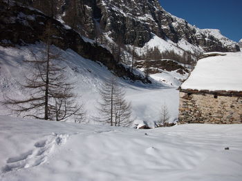 Snow covered land and mountains against sky