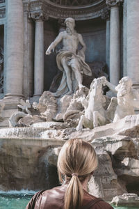 Rear view of a statue against historic building