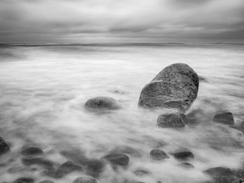 Scenic view of rocks on beach against sky
