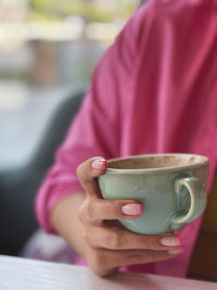 Close-up of hand holding coffee cup