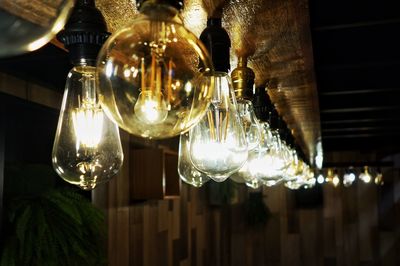 Low angle view of illuminated light bulb hanging