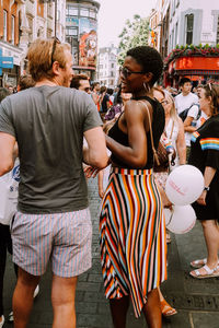 Rear view of people standing on street in city