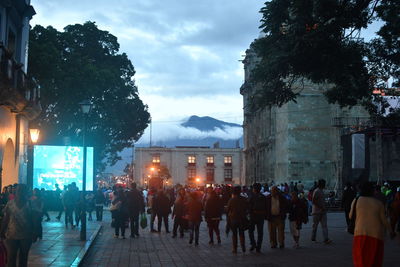 People on street in city against sky