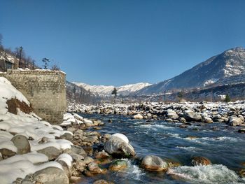 Scenic view of mountains against clear sky during winter