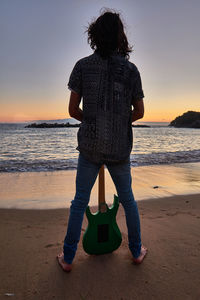 Rear view of man standing on beach