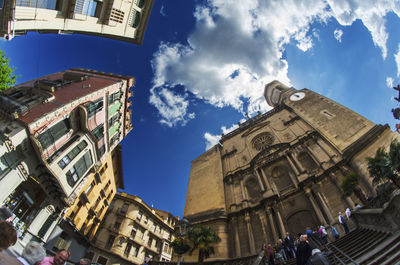 Low angle view of buildings against cloudy sky
