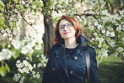 Young woman standing against plants