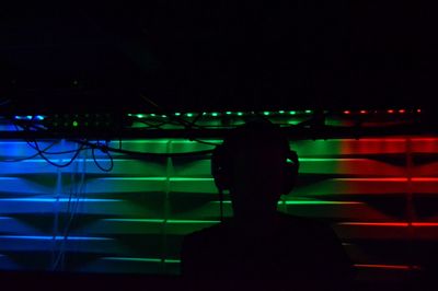 Rear view of silhouette man standing at illuminated nightclub