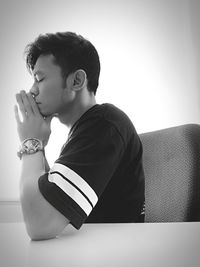 Portrait of young man looking away against white background