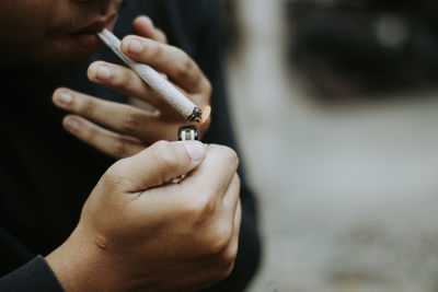 Midsection of man lighting cigarette