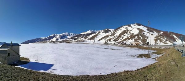 Scenic view of snowcapped mountains against clear blue sky