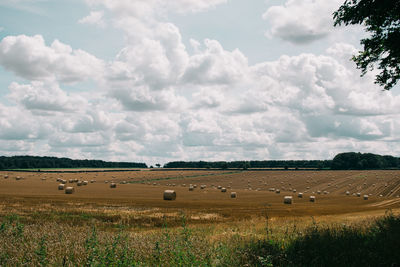 Hay bales on field against sky