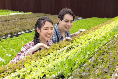 Portrait of smiling young woman standing amidst plants