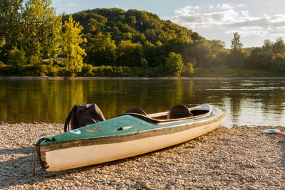 Boat moored at lakeshore against sky