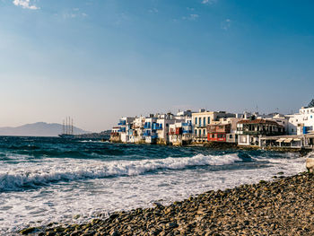 Residential district by sea against blue sky