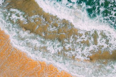 High angle view of waves rushing towards shore