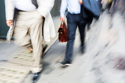 Low section of woman walking on road