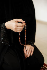 Prayer hands of a woman holding a rosary. ramadan kareem