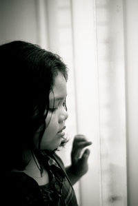 Portrait of woman looking away against window