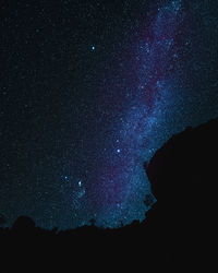 Low angle view of silhouette trees against sky at night