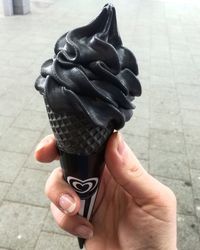 Close-up of person holding ice cream on footpath