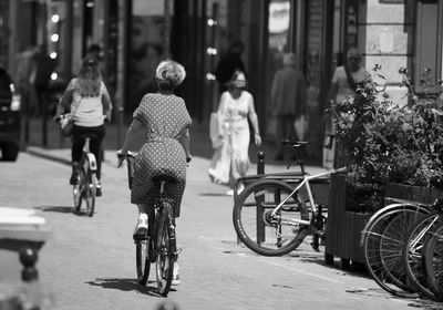 People riding bicycle on street in city